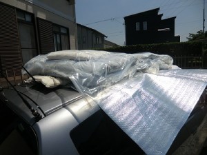 車の屋根にアルミシートを敷いて・・・。